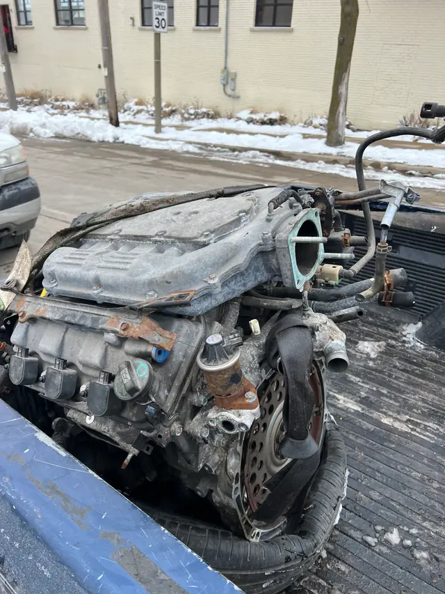 A used engine pulled at A & D riding in the bed of a pickup on a snowy Milwaukee street
