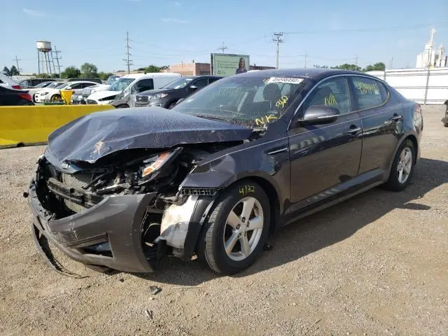 A wrecked sedan in the A & D gravel yard with stock-number stickers on the windshield